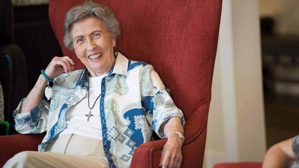 Senior woman seated in highback chair